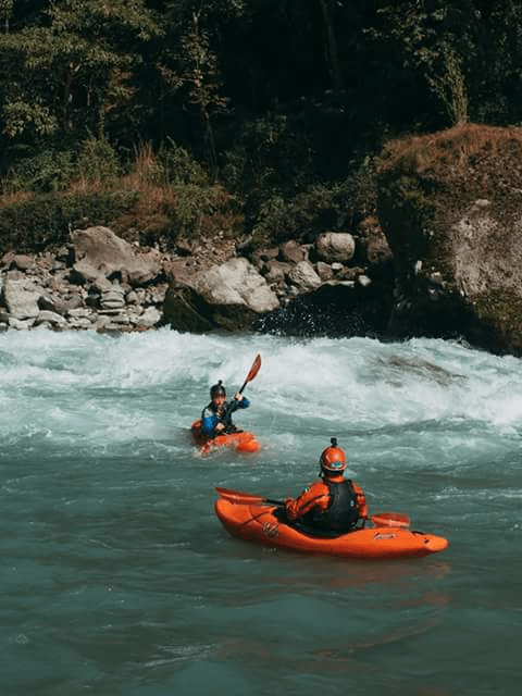 (Dipesh (orange helmet) encouraging Kaja (black helmet) on the Bheri River, Nepal)